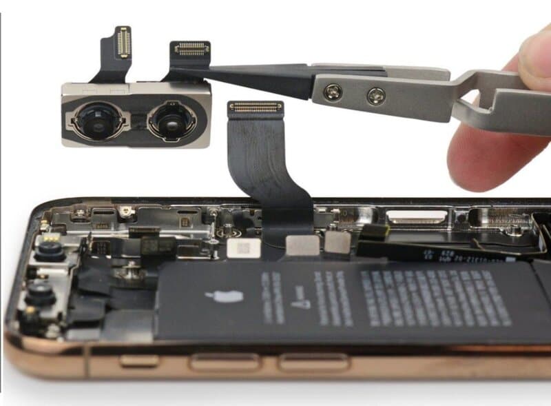 iPhone repair: Close-up of a disassembled iPhone with the camera module being removed using tweezers. ER4Gadgets