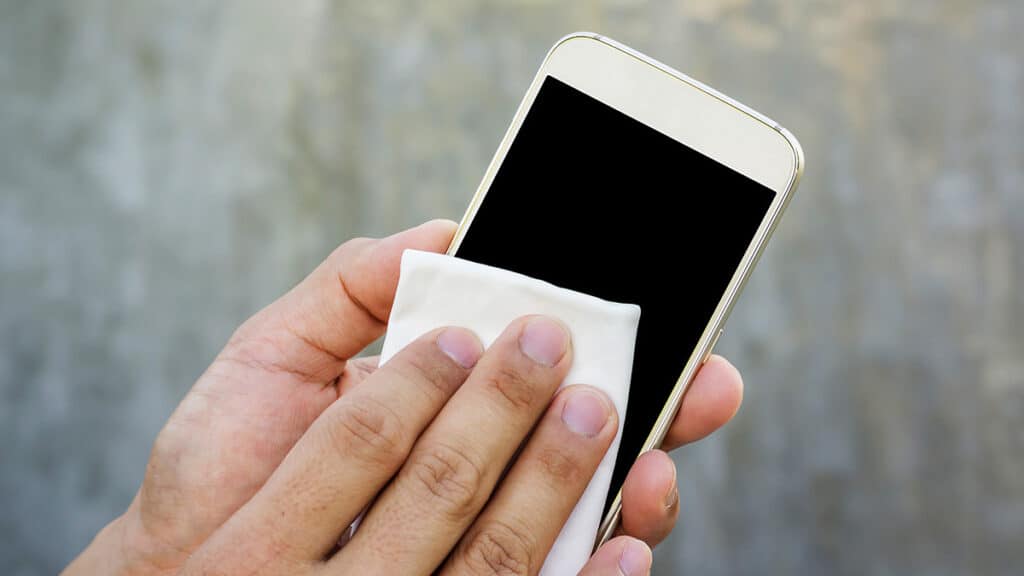 Cleaning an iPhone screen with a soft white cloth. Keeping your device clean. ER4Gadgets