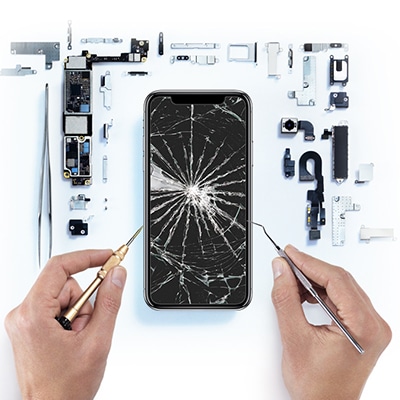 Cracked smartphone screen with repair tools and phone components. Smartphone repair. ER4Gadgets