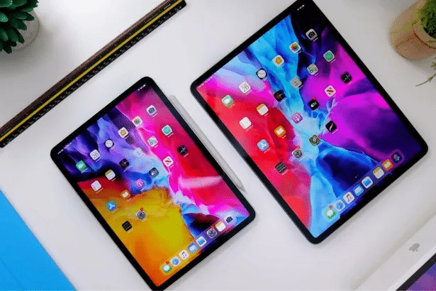 Two Apple iPads displaying colorful home screens, alongside an Apple Pencil and a ruler. ER4Gadgets